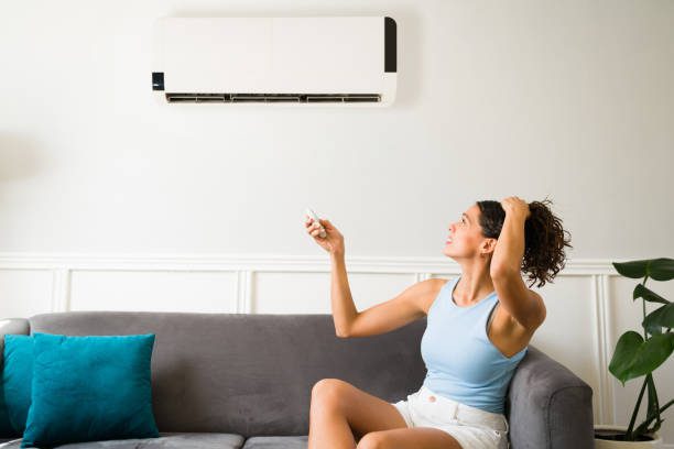 Hot young woman feeling sweaty during a heat wave because her air conditioning is not working