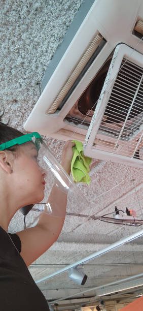 Store clerk with protection screen cleaning air conditioning filter